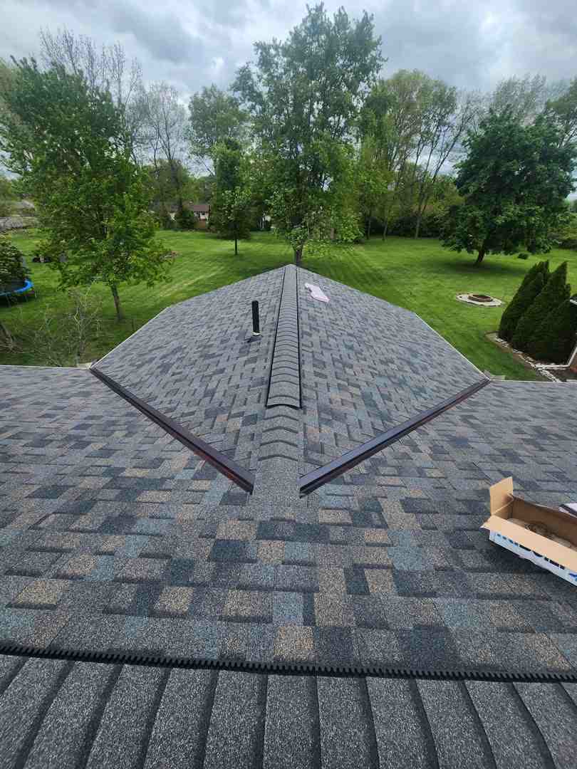 Looking along the ridge of a new gray shingle roof