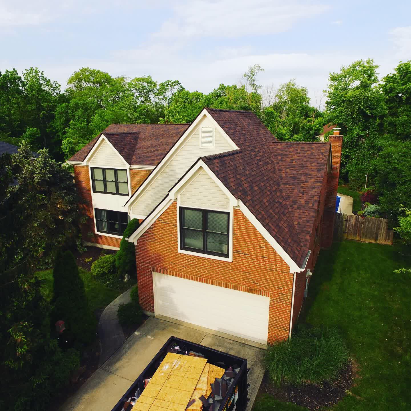 Drone photo of a brick home with a new brown shingle roof