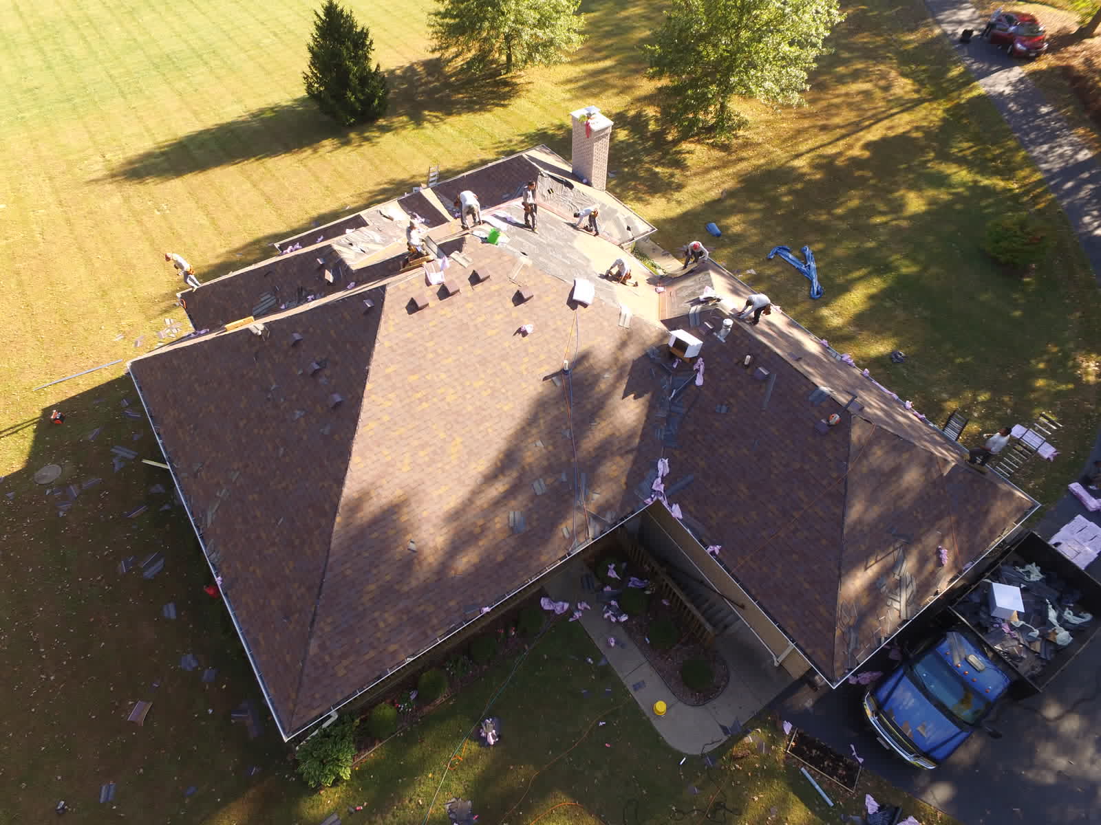 Brown shingle hip roof during a replacement, seen from overhead