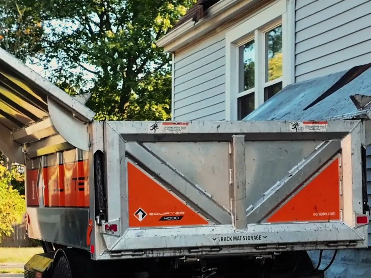The Equipter debris trailer beside a home