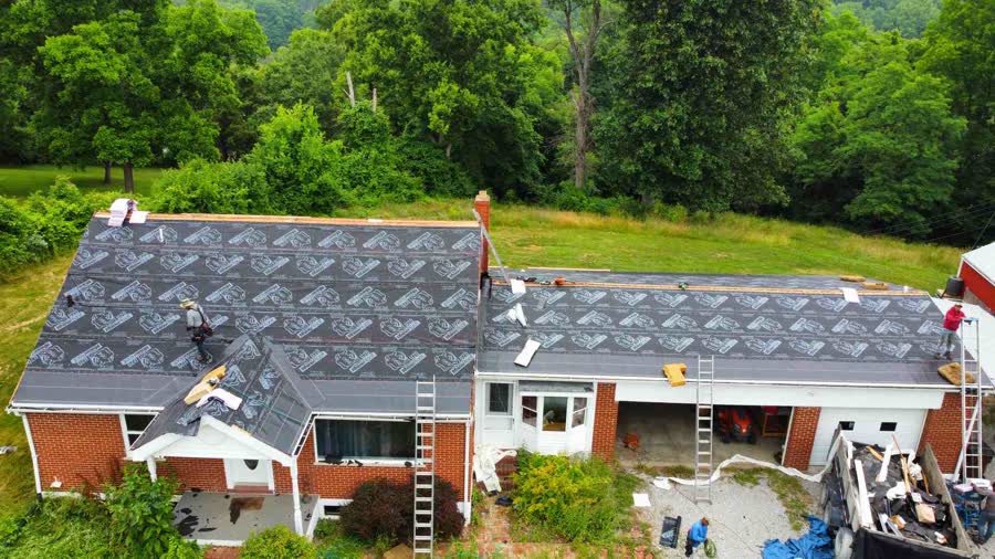 Drone photo of roofers laying underlayment on a ranch home