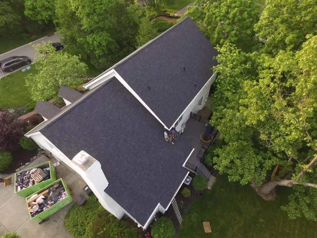 Finished dark shingle roof surrounded by trees