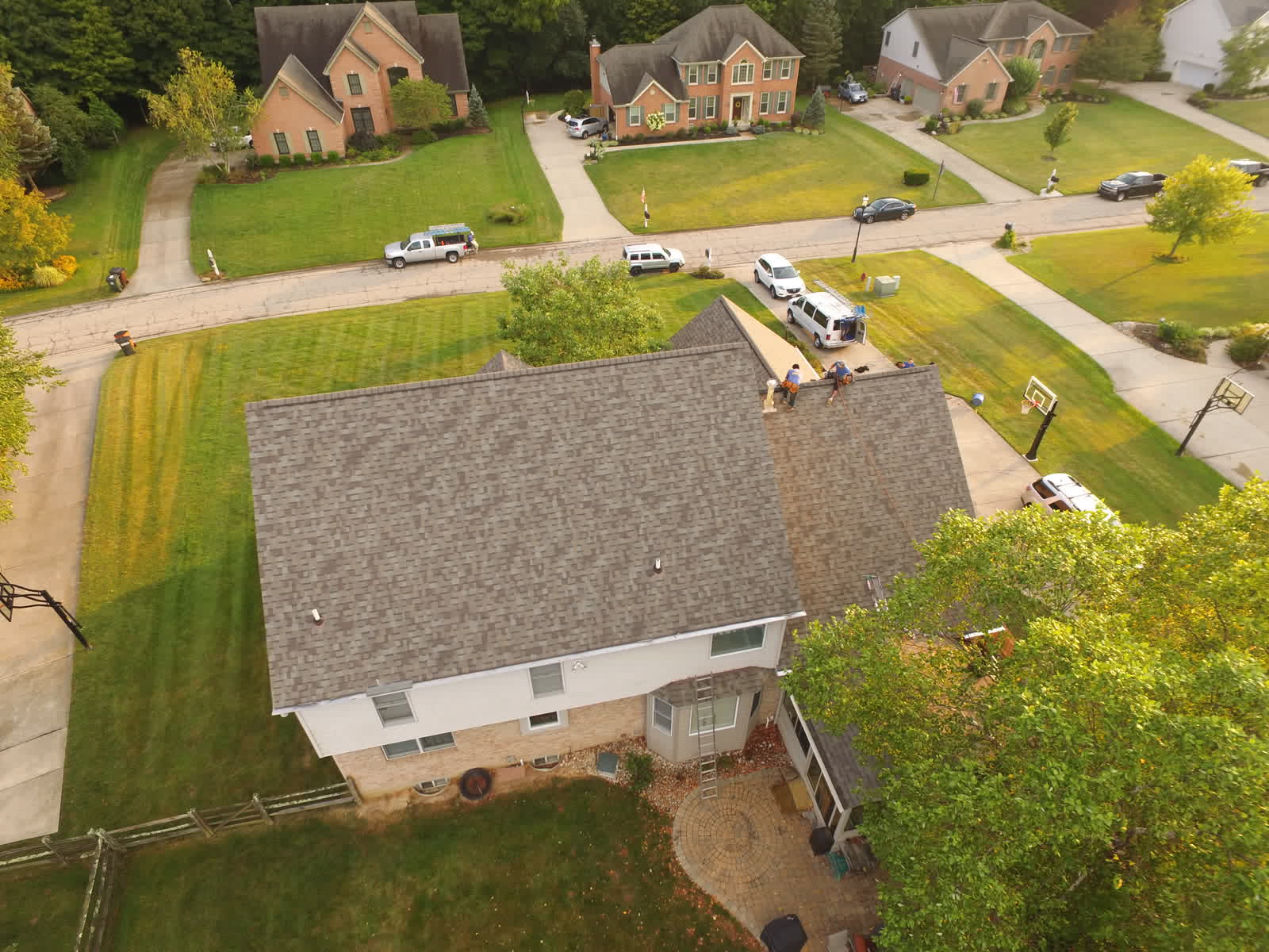 Drone photo of a home with a new gray shingle roof on a corner lot