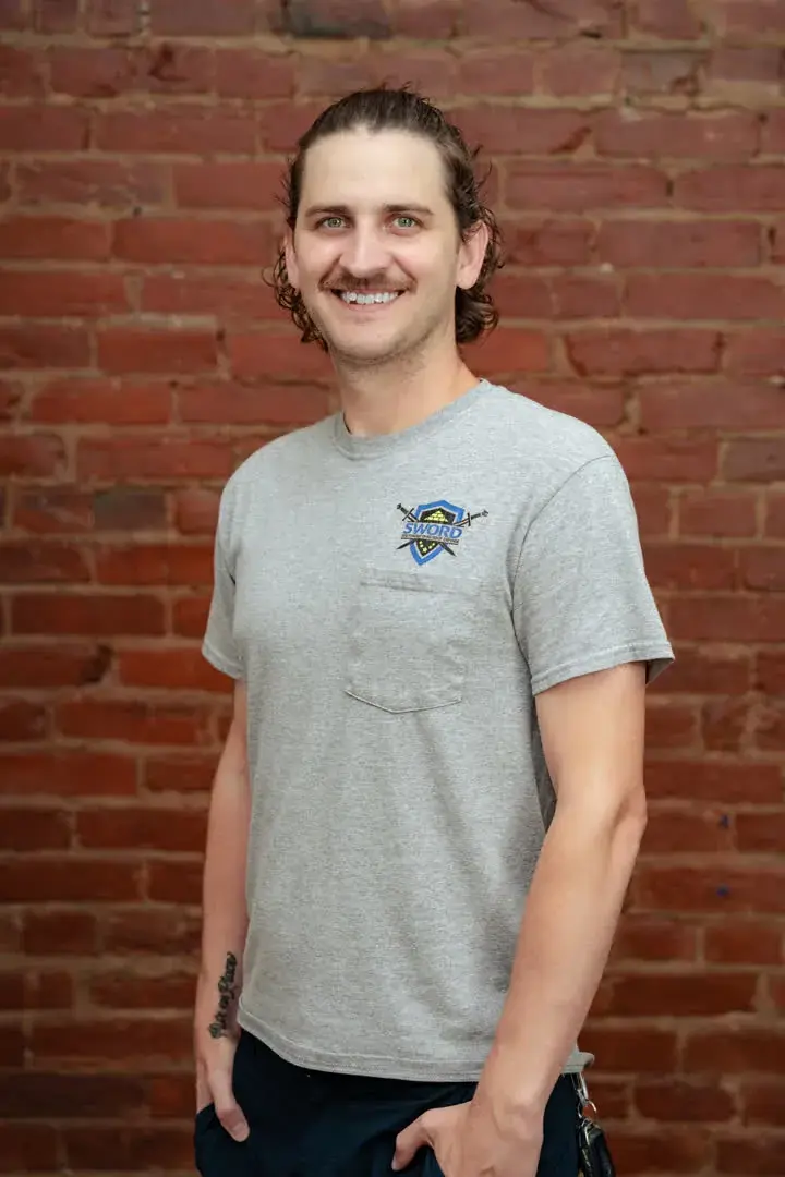 Justin Huber, co-owner of SWORD Roofing, in a gray SWORD shirt