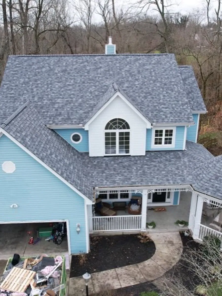New shingle roof on a blue two-story home