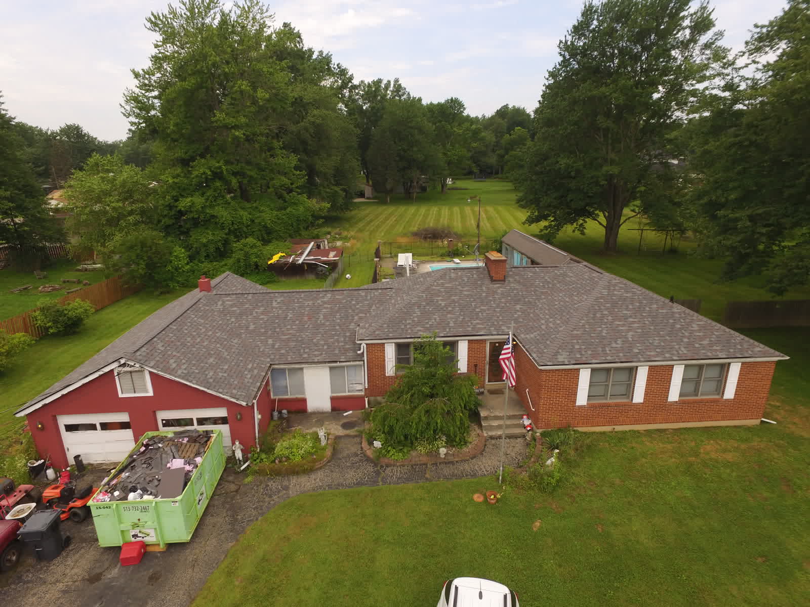 Drone photo of a red brick ranch with a new gray shingle roof