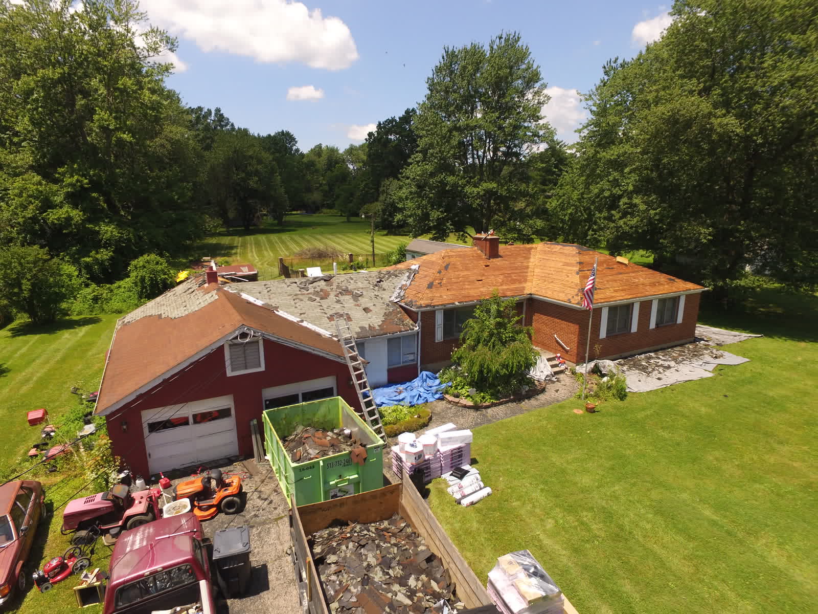 Drone photo of a roof replacement: old shingles coming off a red brick ranch