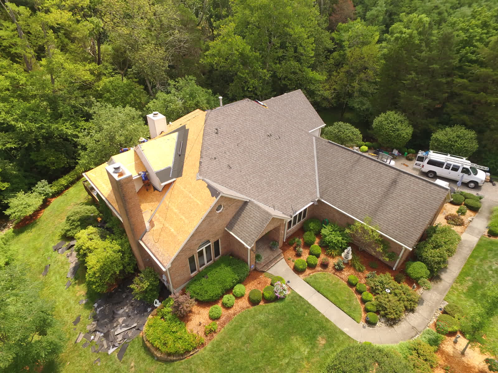Drone photo of a roof replacement: roof stripped to the decking on a brick home