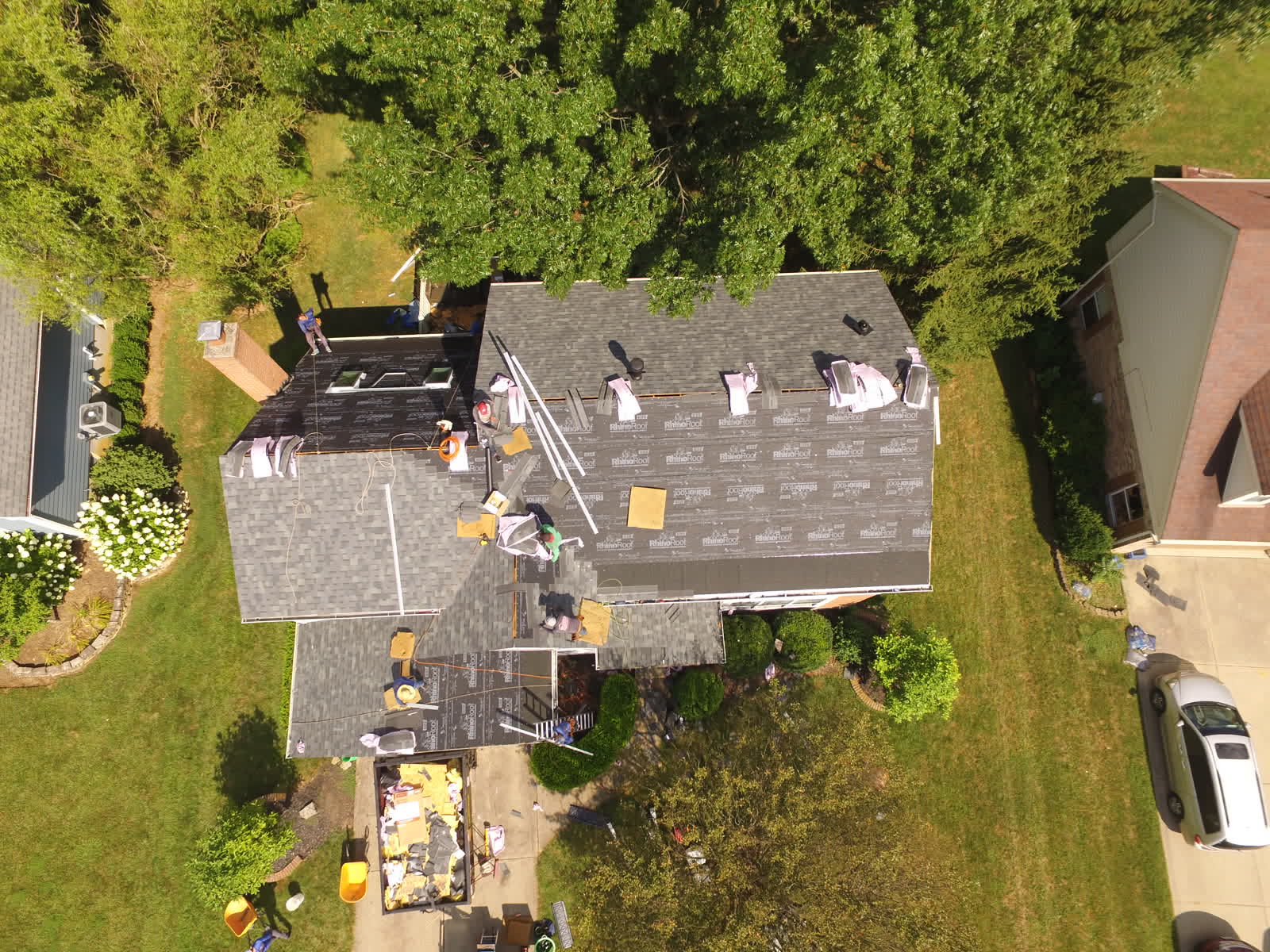 Overhead drone photo of roofers installing new shingles on a two-story home