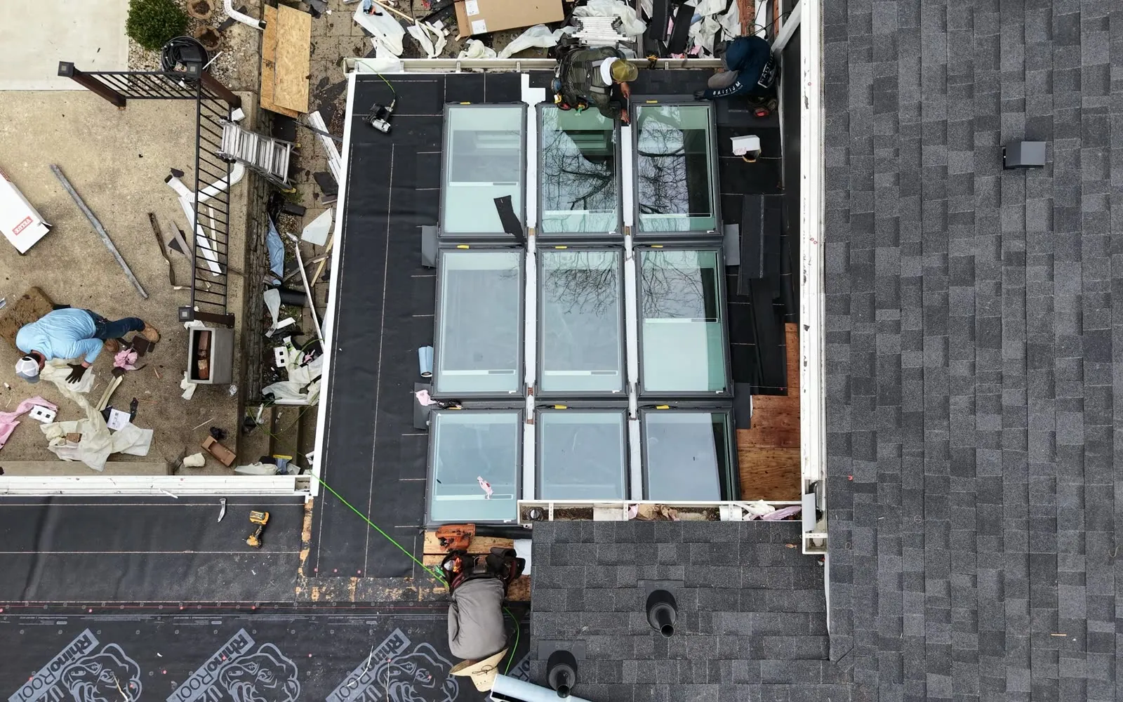 Roofers flashing around a bank of skylights