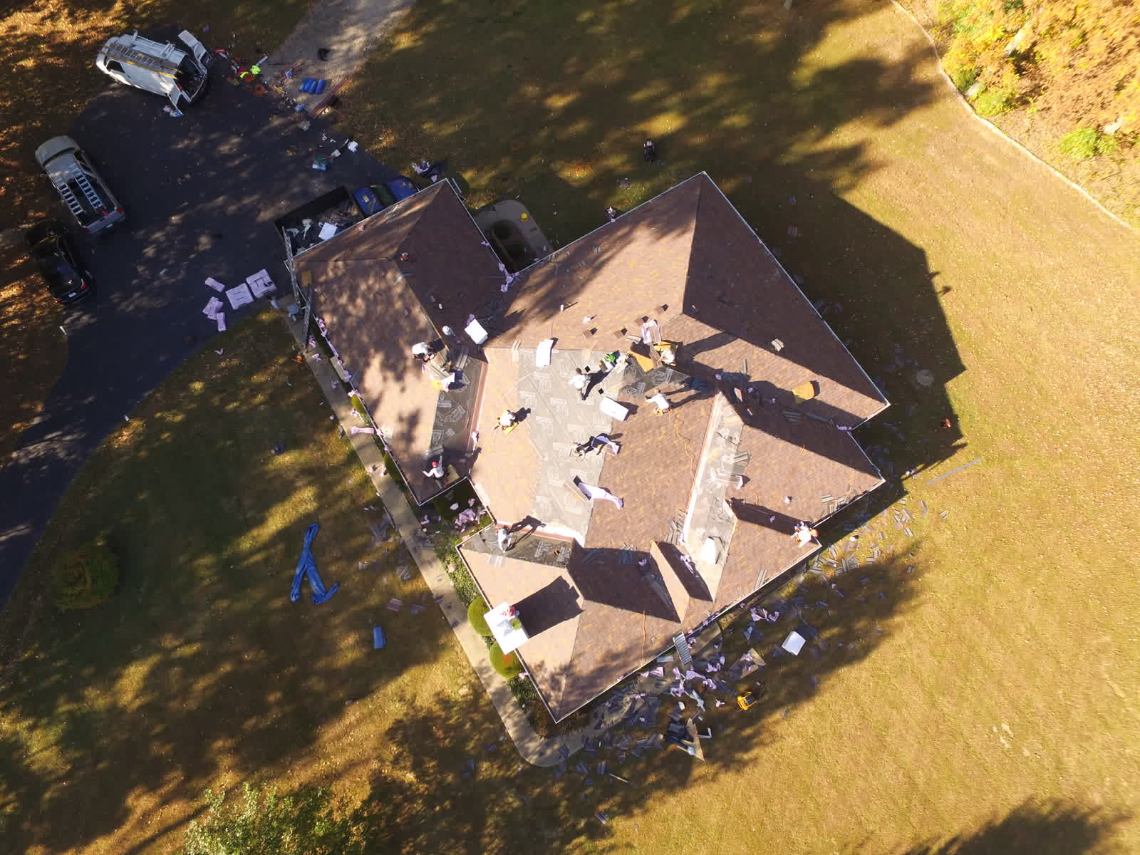 Roofers tearing off an old hip roof, seen from overhead