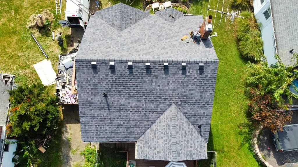 Drone photo of roofers working on a section of a shingle roof