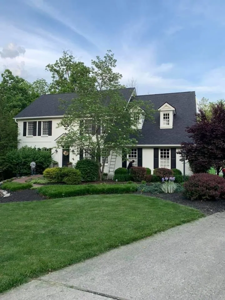 Two-story home with a dark shingle roof, seen from the front lawn