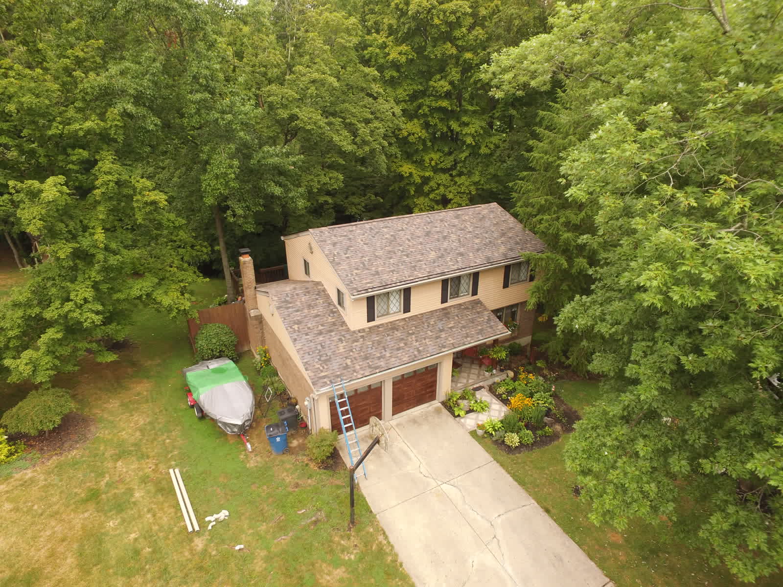 Drone photo of a two-story home with a new tan shingle roof