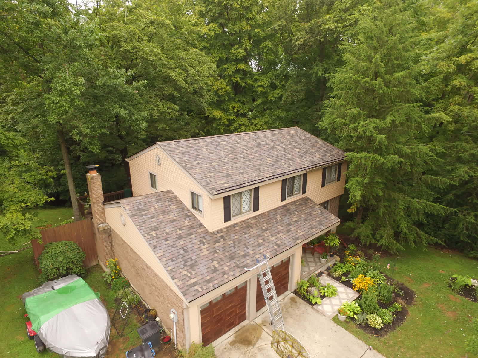 Drone photo of a two-story home with a tan shingle roof