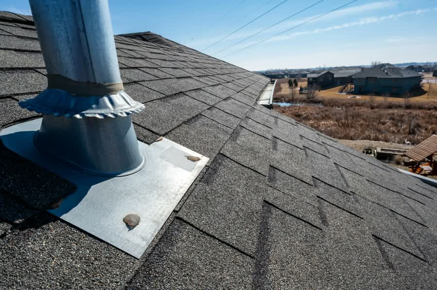 Metal flashing around a vent pipe on a shingle roof