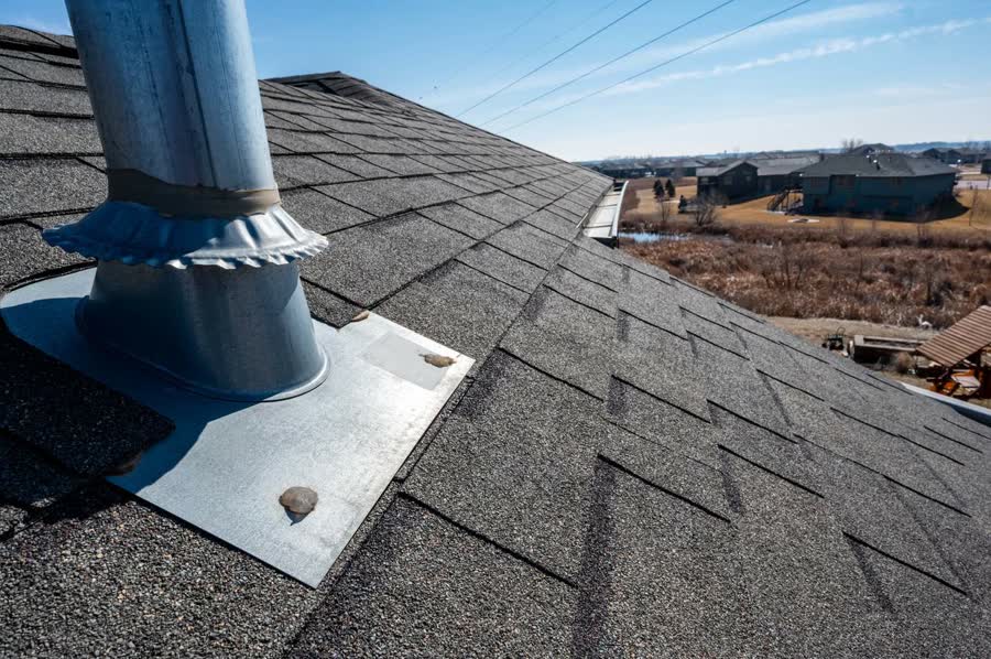 Metal flashing around a vent pipe on a shingle roof
