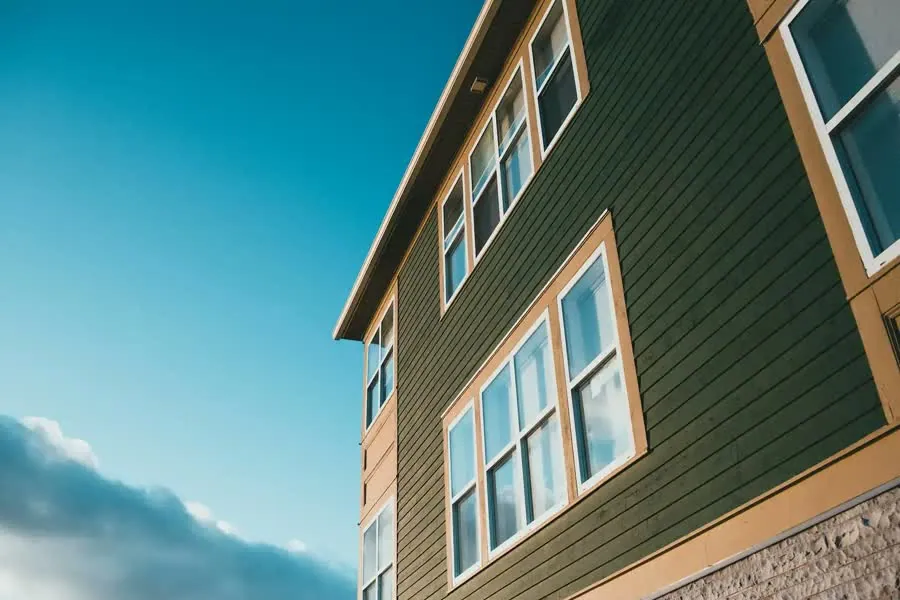 Green siding on the side of a three-story home